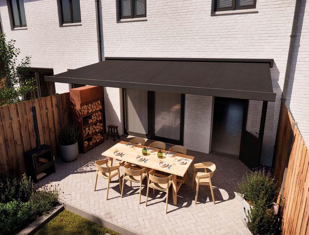 Anthrazitfarbene Kassettenmarkise über einer Terrasse mit gedecktem Esstisch