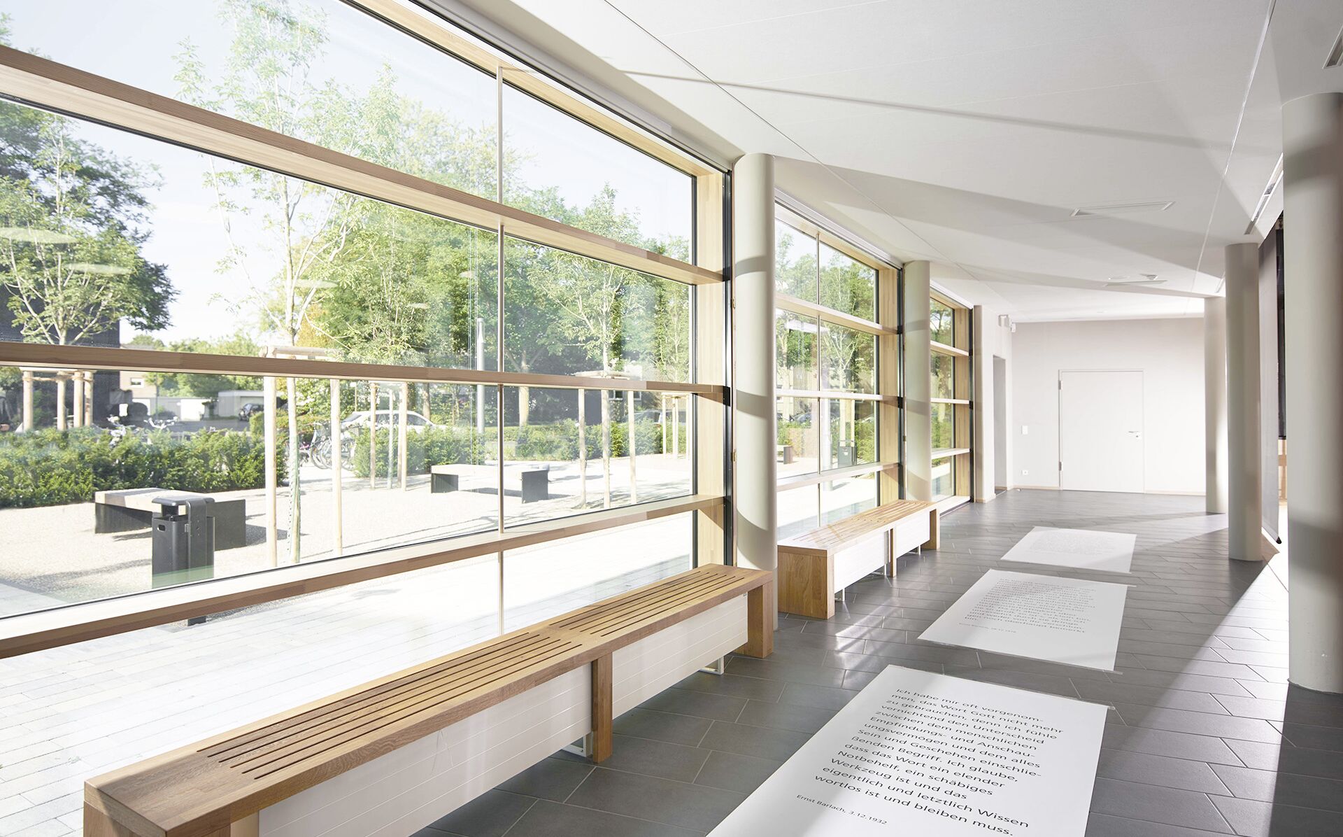 Innenansicht der Aula eines Schulgebäudes mit UNILUX FineLine Pfosten-Riegel-Fassade