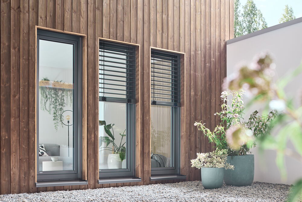 Holzfassade mit drei bodentiefen WERU Impreo-top Kunststoff-Aluminium-Fenstern