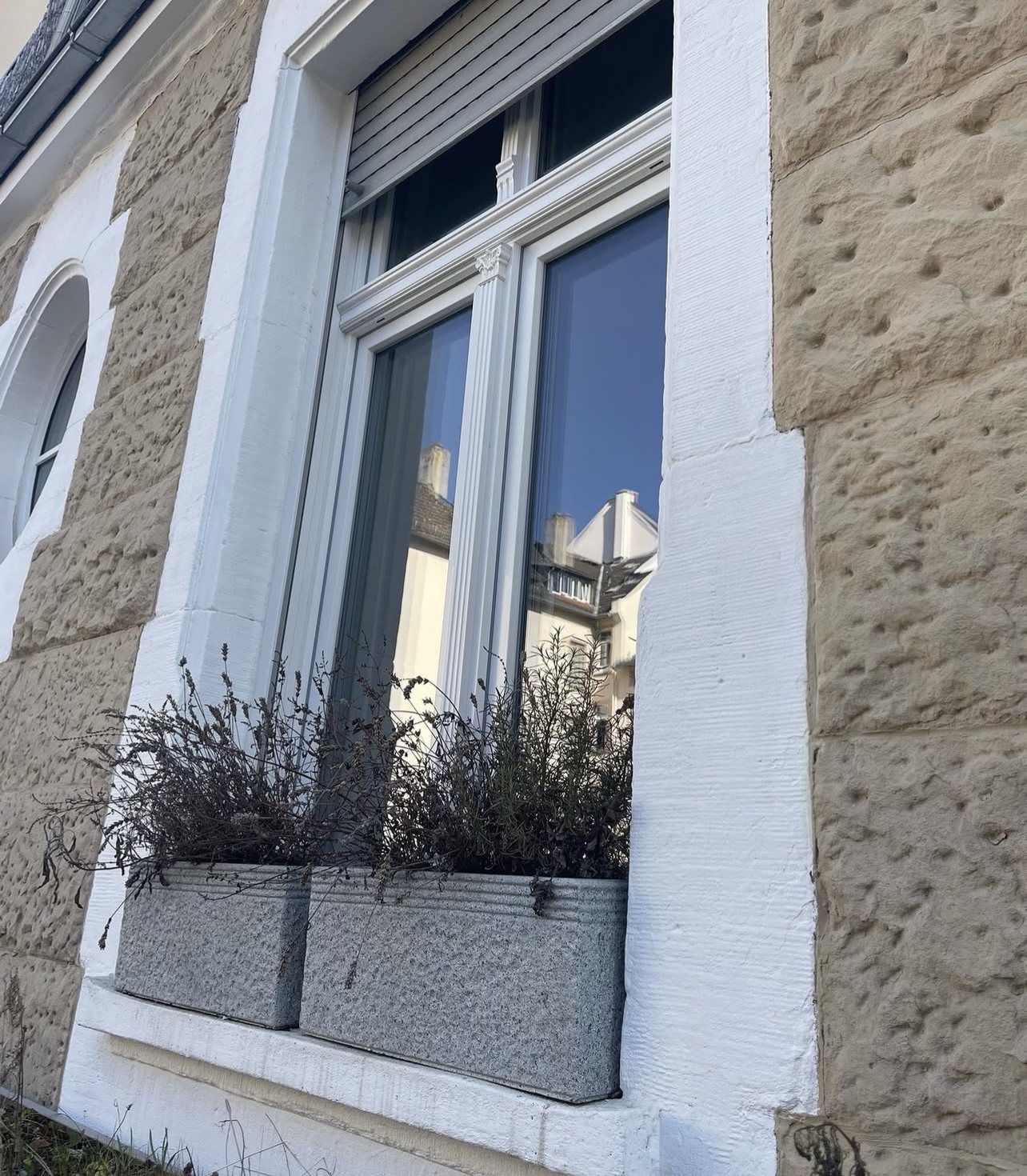 Neues Kunststofffenster mit Zierelementen und Rollladen in der Sandsteinfassade des Gründerzeithauses